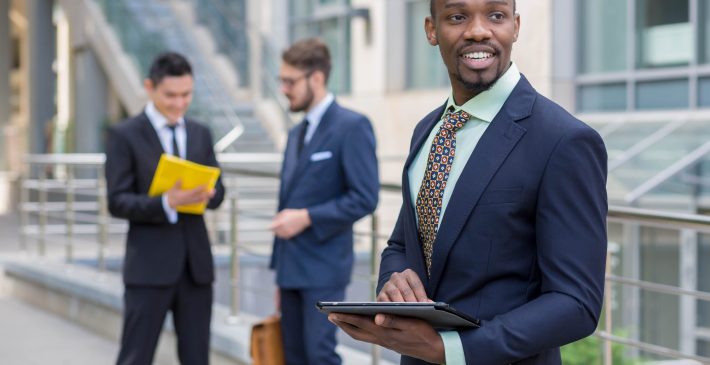 Portrait of multi ethnic business team Portrait of multi ethnic business team. Three happy smiling men standing against the backdrop of the city. The one man is African-American, other is Chinese and European. concept of business success