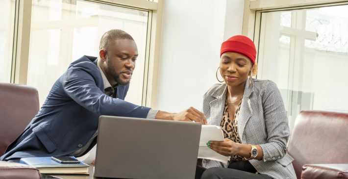 Young black businessman and woman going through some paperwork together A young black businessman and woman going through some paperwork together
